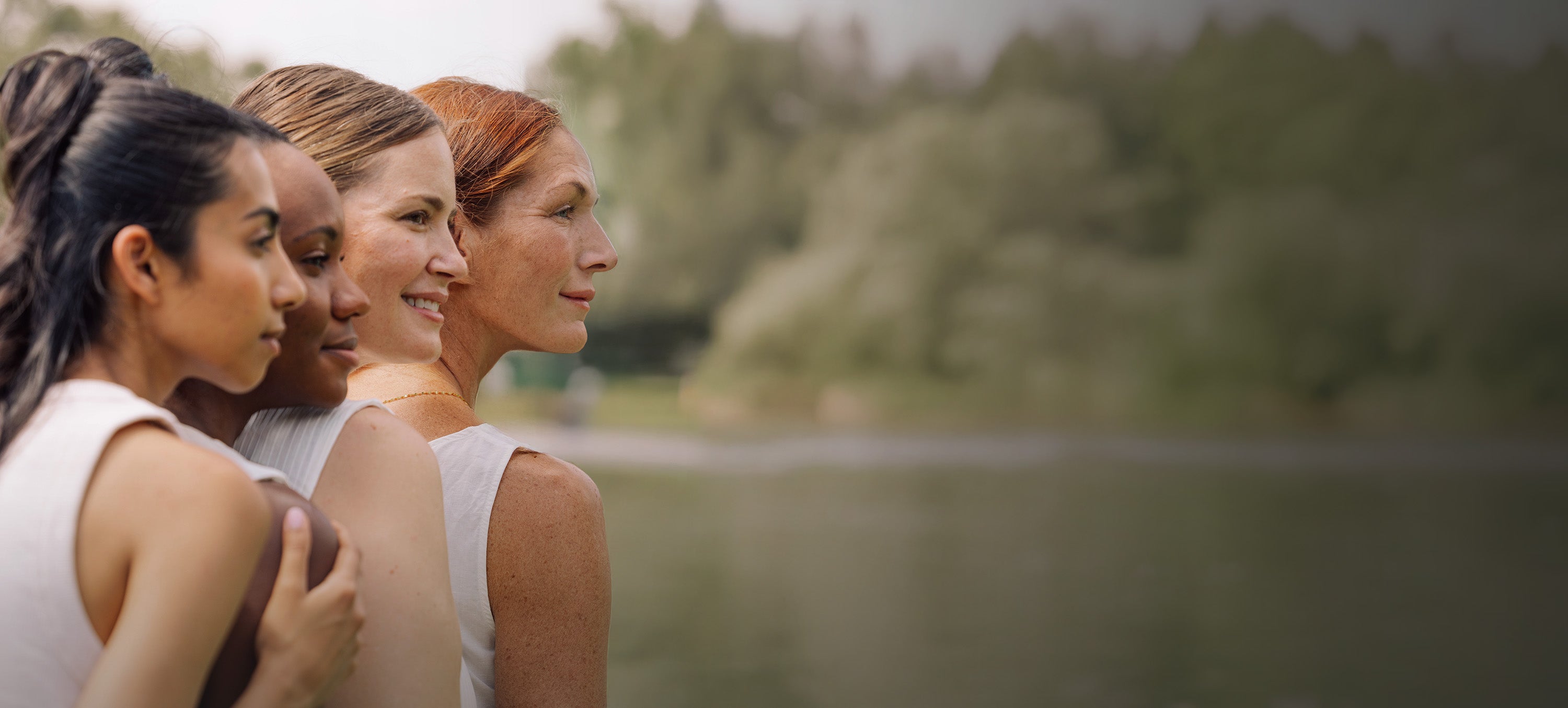 Three women standing close together with a natural background