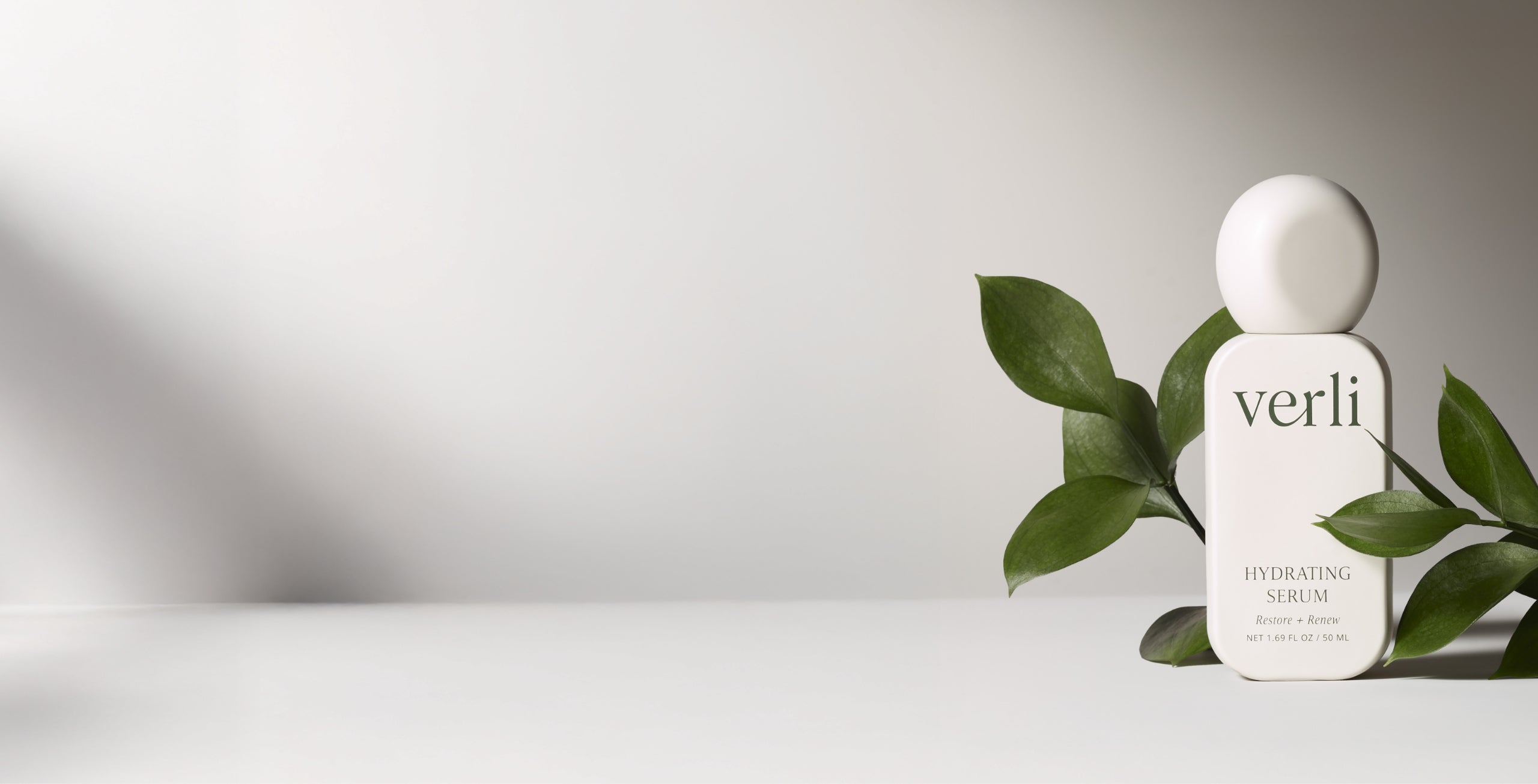Verli skincare bottle with green leaves on a light background